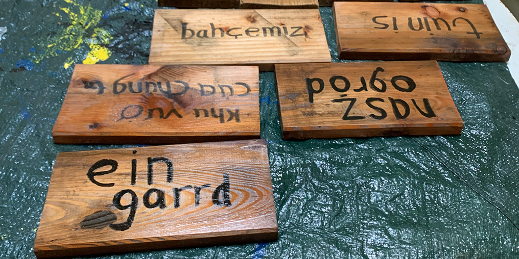 Our garden' wooden signs in different languages.
