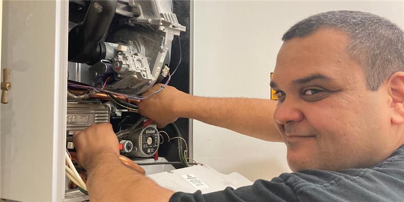 A Gas Safe registered engineer working on a boiler.