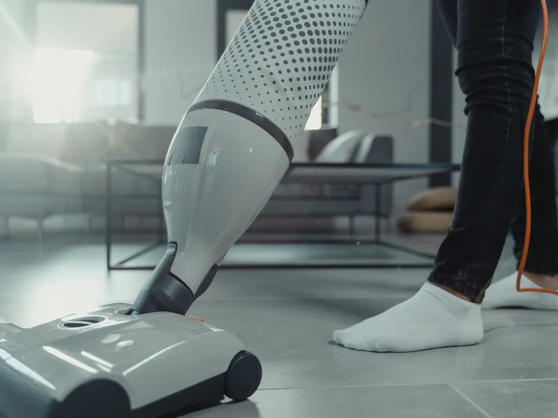 Someone uses a hoover at home. 