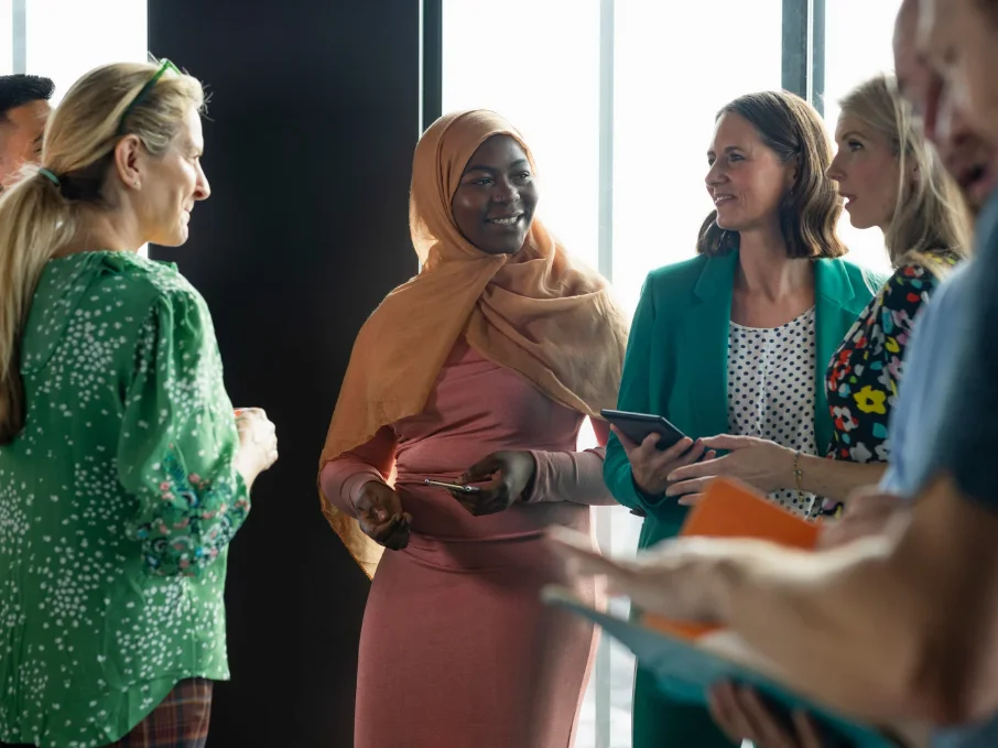 A group of people chat happily. 